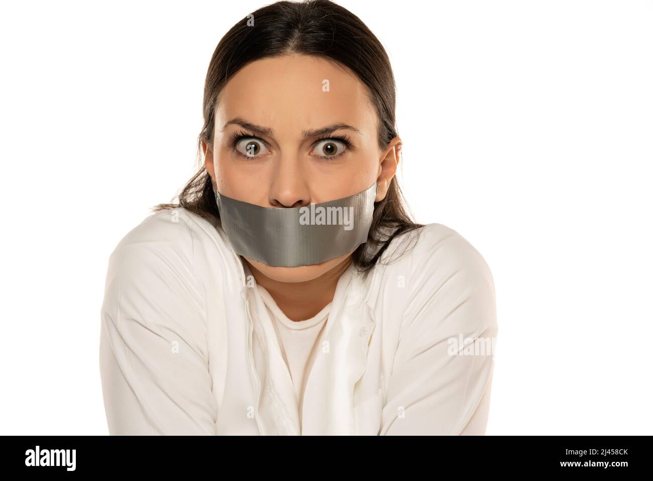 Unglückliche junge Frau mit Klebeband über ihrem Mund auf weißem Hintergrund Stockfoto