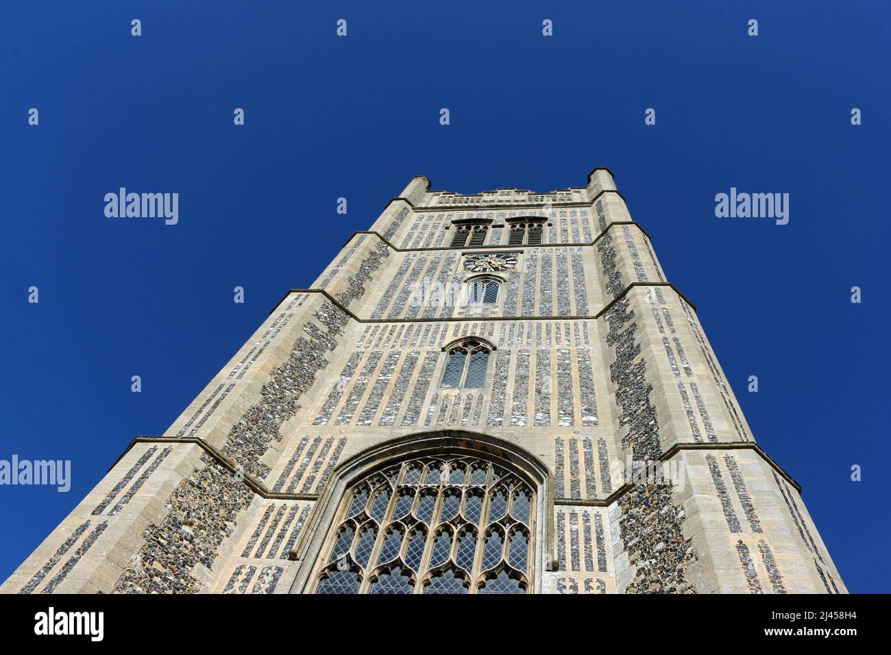 Westturm der Pfarrkirche St. Peter und St. Paul in Suffolk und blauer Himmel ohne Wolke im Hintergrund. Stockfoto