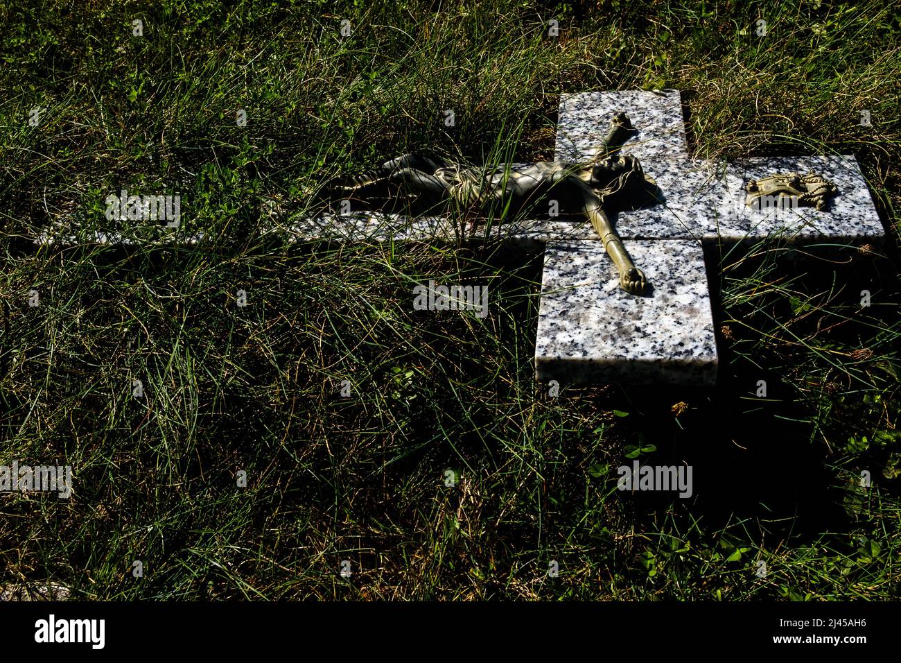 Jesus Christus auf dem mit Gras bewachsenen Kreuz auf einem verlassenen Grab auf dem Friedhof von Reaux (Zentralfrankreich) Stockfoto