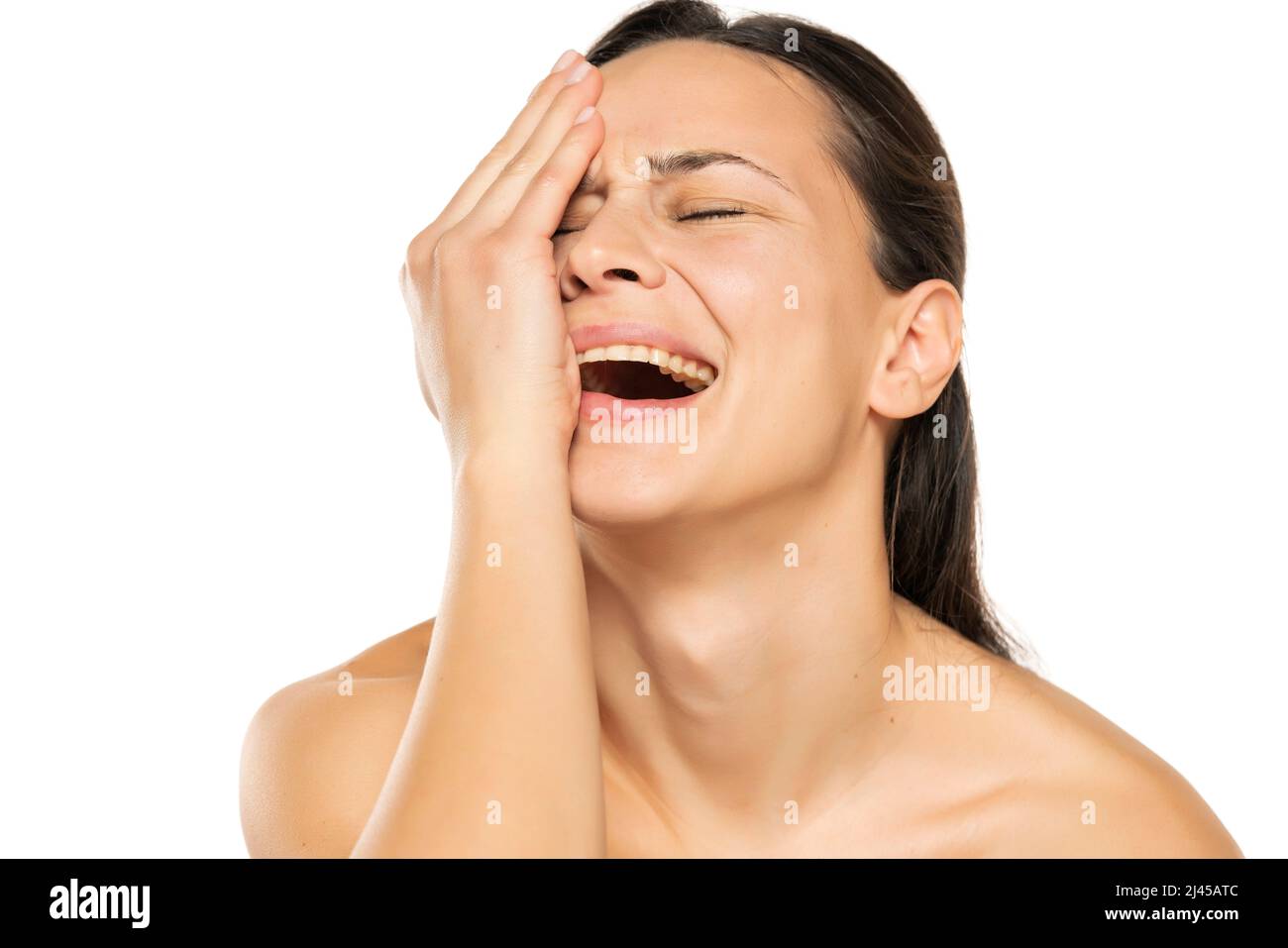 Eine verzweifelte weinende junge Frau auf weißem Hintergrund Stockfoto