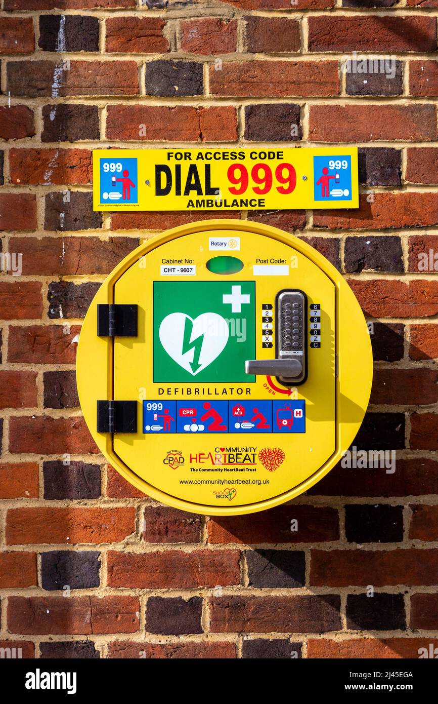 Code-verriegelter Notfall-Defibrillator an einer Ziegelwand montiert Stockfoto