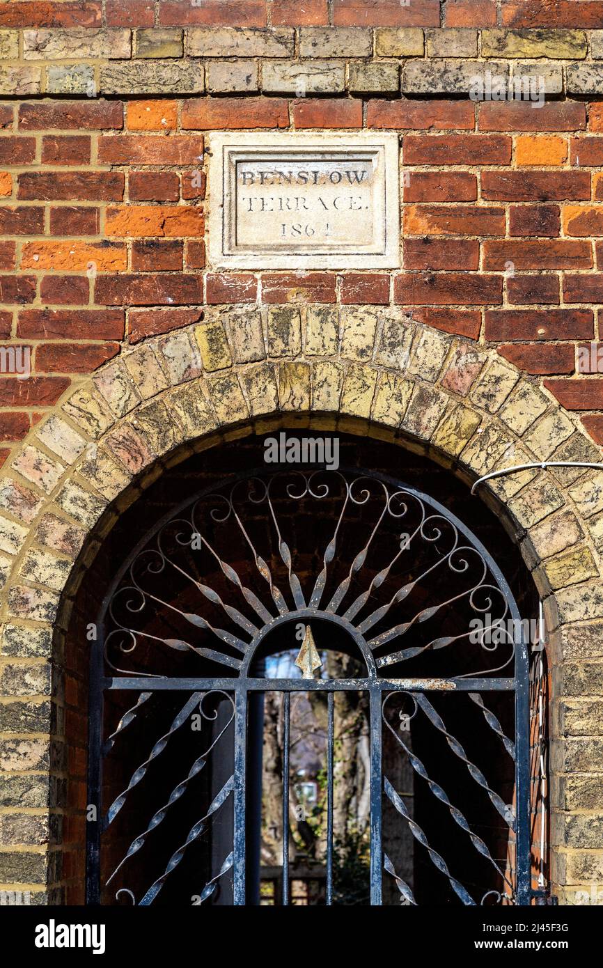 Detail eines eisernen Tores zu einer Passage durch die Benslow Terrace, die im 19.. Jahrhundert in der Benslow Lane, Hirchin, Hertfordshire, Großbritannien, erbaut wurde Stockfoto