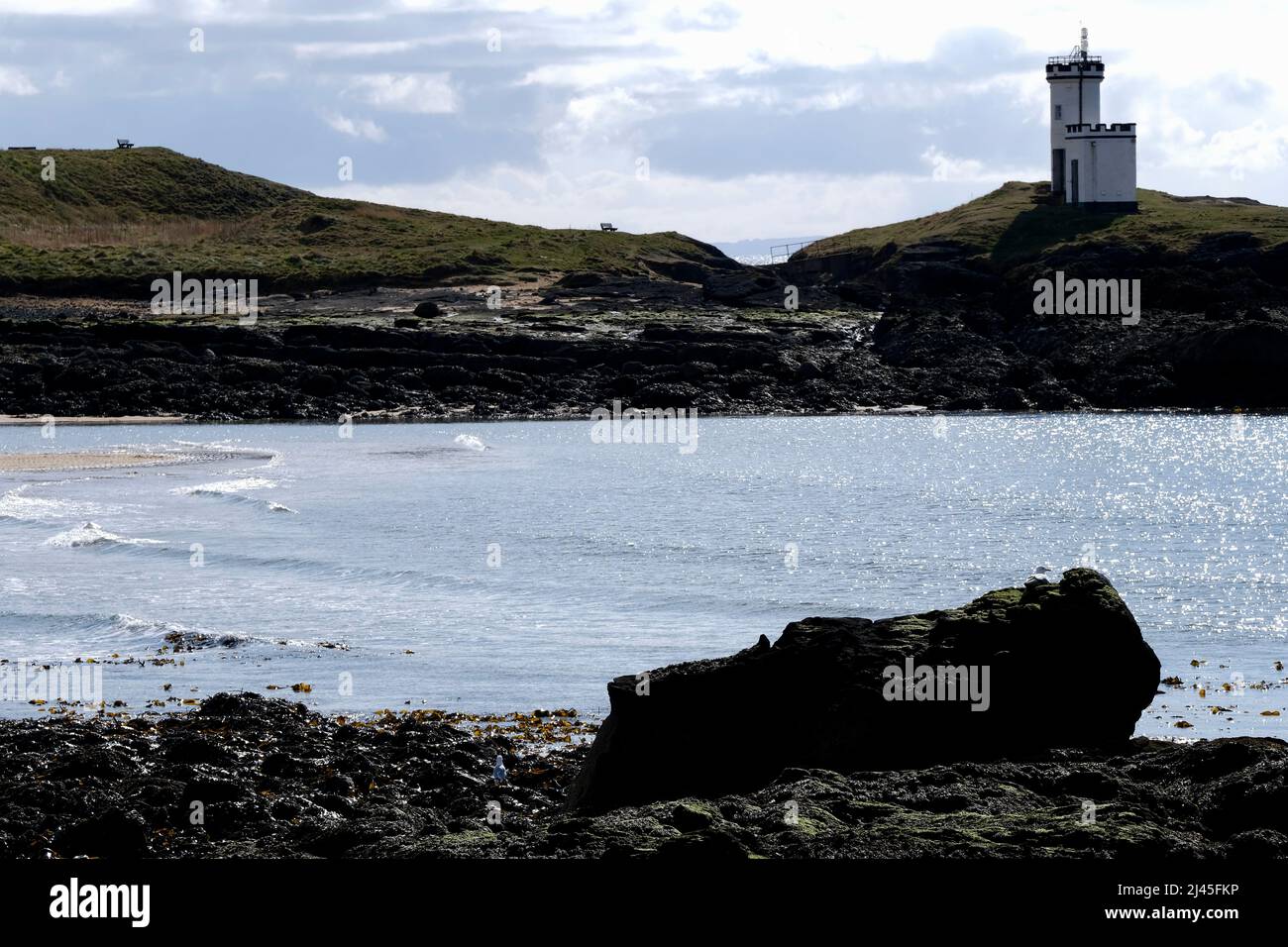 Elie Fife Schottland ein Küstenresortdorf, die Flut ist draußen und Einheimische und Touristen genießen einen Spaziergang am Strand. Blauer Himmel an einem frühen Frühlingstag. Stockfoto