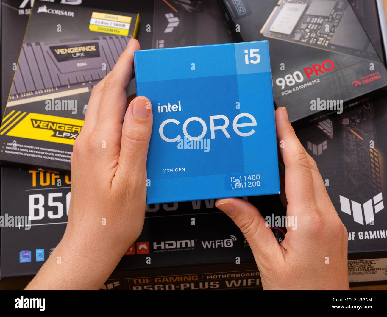 Tambow, Russische Föderation - 07. April 2022 Eine Frau hält eine Box mit einer Intel Core i5 11400 CPU über andere Boxen mit brandneuen Komponenten in Stockfoto