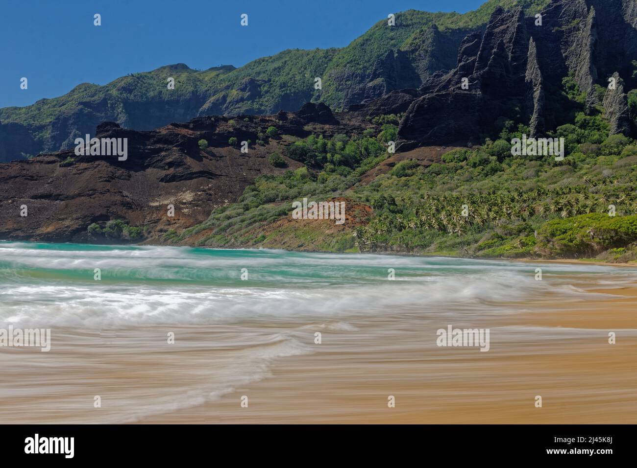 Marquesas-Inseln, Nuku Hiva: Strand in der Bucht von Haatuatua, gesäumt von Klippen Stockfoto