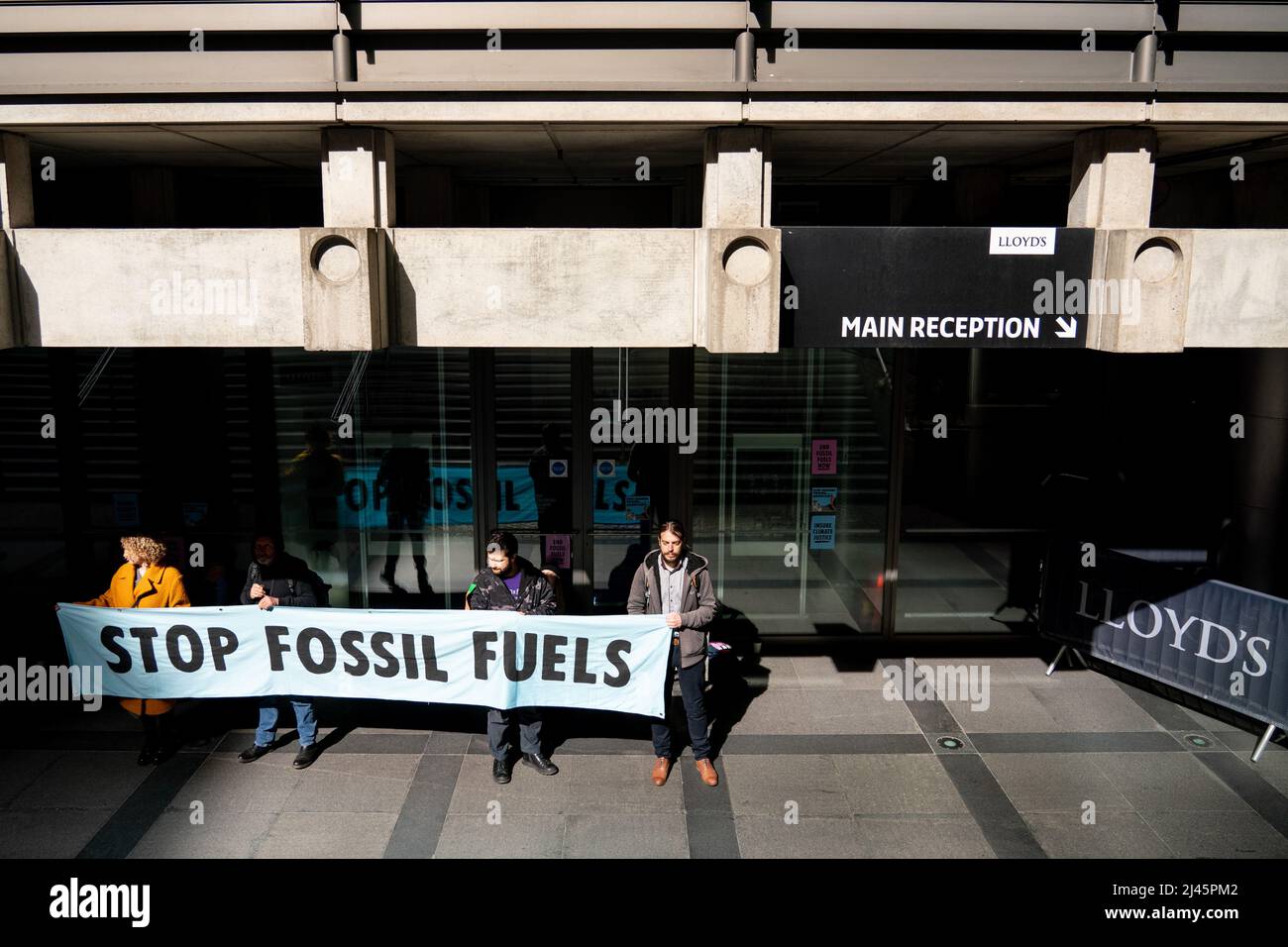 Aktivisten von Extinction Rebellion blockieren den Eingang zu Lloyds of London in der City of London, da sie Lloyds dazu aufrufen, die Versicherung von Projekten für fossile Brennstoffe weltweit einzustellen. Bilddatum: Dienstag, 12. April 2022. Stockfoto