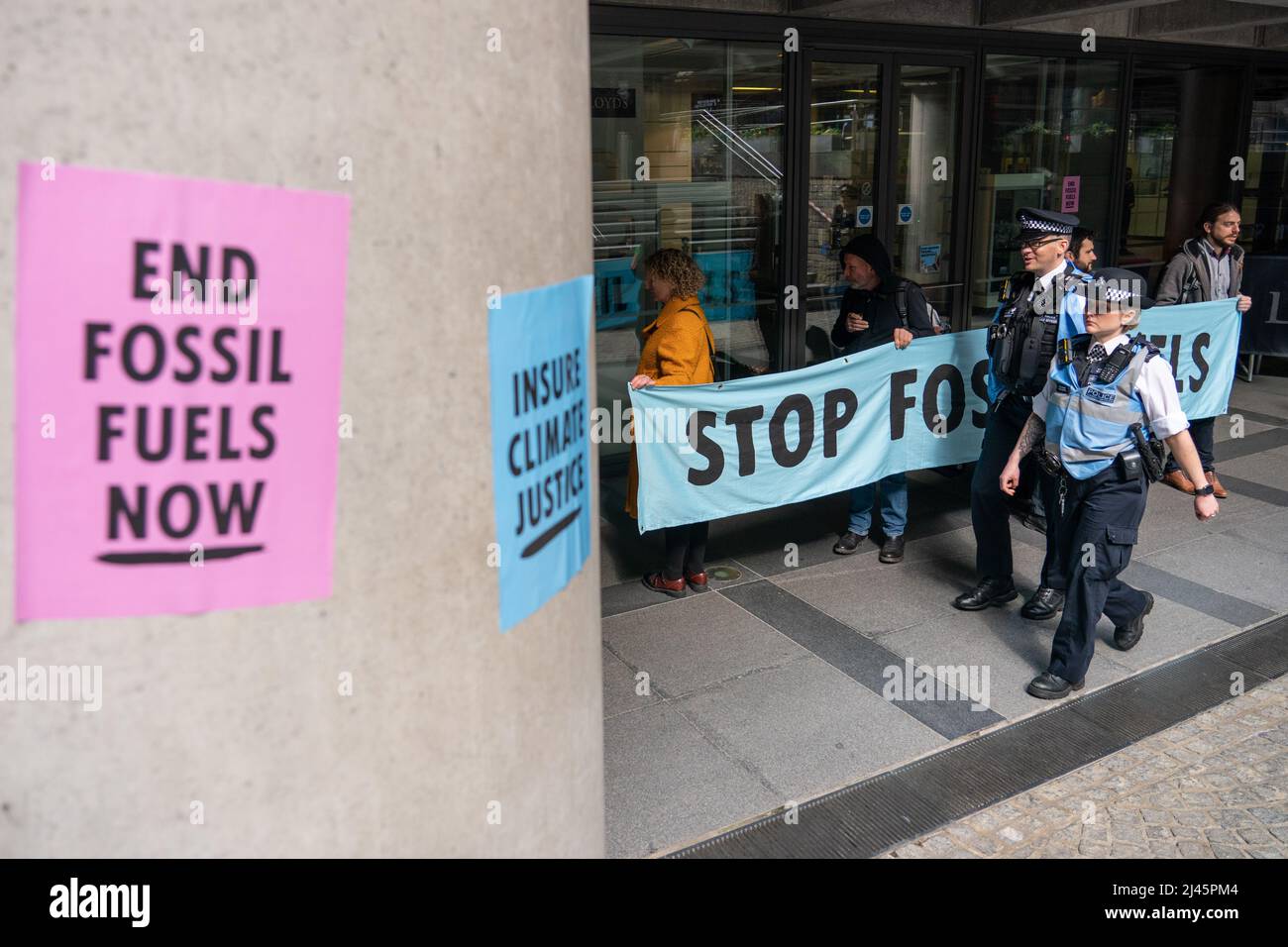 Aktivisten von Extinction Rebellion blockieren den Eingang zu Lloyds of London in der City of London, da sie Lloyds dazu aufrufen, die Versicherung von Projekten für fossile Brennstoffe weltweit einzustellen. Bilddatum: Dienstag, 12. April 2022. Stockfoto
