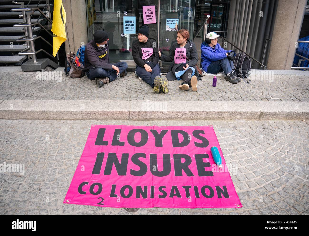 Aktivisten von Extinction Rebellion blockieren den Eingang zu Lloyds of London in der City of London, da sie Lloyds dazu aufrufen, die Versicherung von Projekten für fossile Brennstoffe weltweit einzustellen. Bilddatum: Dienstag, 12. April 2022. Stockfoto