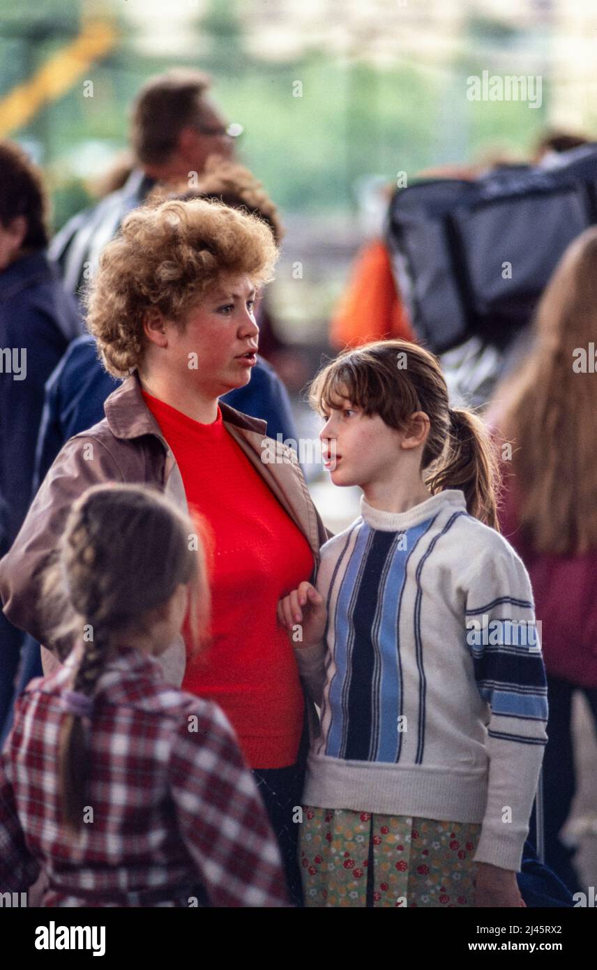Eine junge Mutter und ihre zwei Töchter auf einem Flohmarkt in Moskau, Russland, Mai 1990. Stockfoto