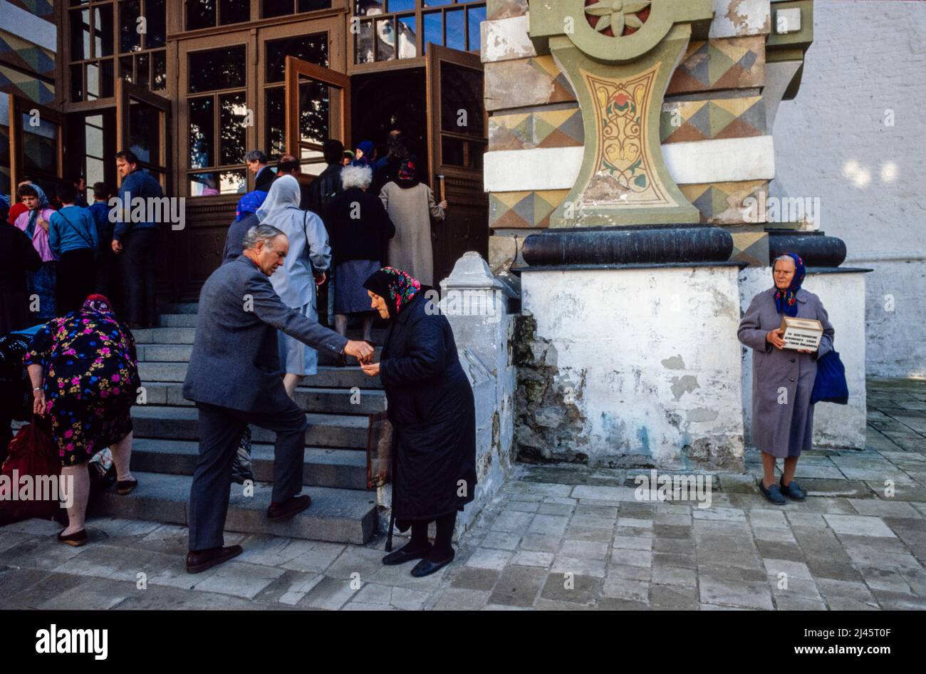 Eine Frau, die vor dem Dreifaltigkeitslawra des heiligen Sergius, dem wichtigsten russischen Kloster der russisch-orthodoxen Kirche, in Sergijew Posad, 70 km von Moskau entfernt, bettelt., Mai 1990 Stockfoto