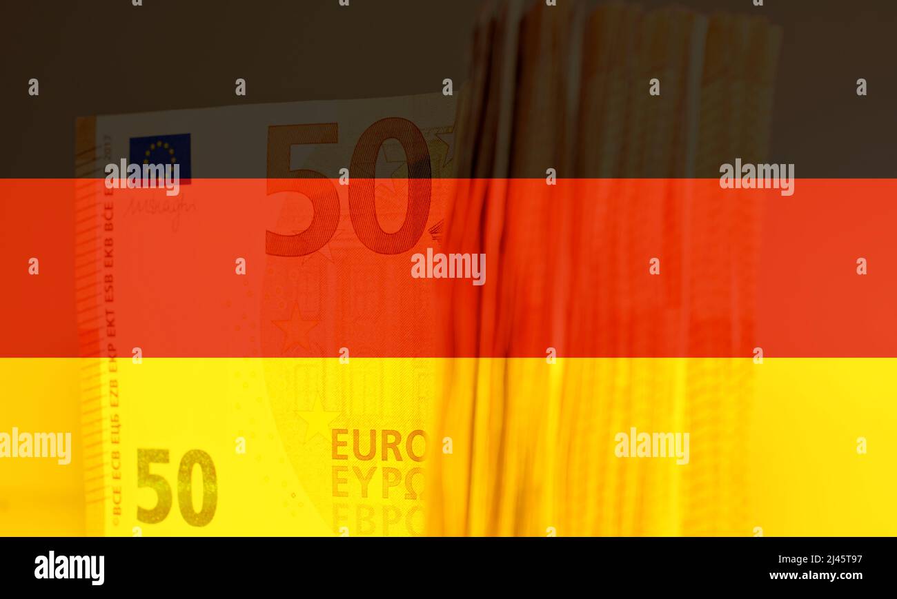 Stapel von fünfzig Euro auf dem Tisch, mit der Deutschlandflagge als Hintergrund. Stockfoto