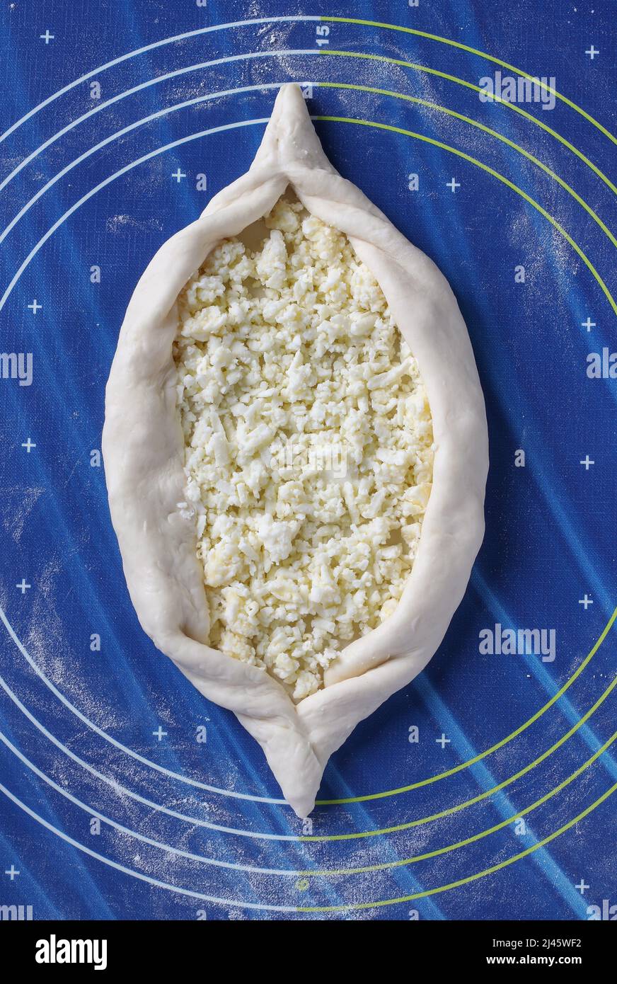 Prozess des Kochens georgischen khachapuri mit Käse, wird ein Boot-förmigen Kuchen aus dem Teig gebildet und mit Käse gefüllt, Schritt für Schritt Anweisungen Stockfoto