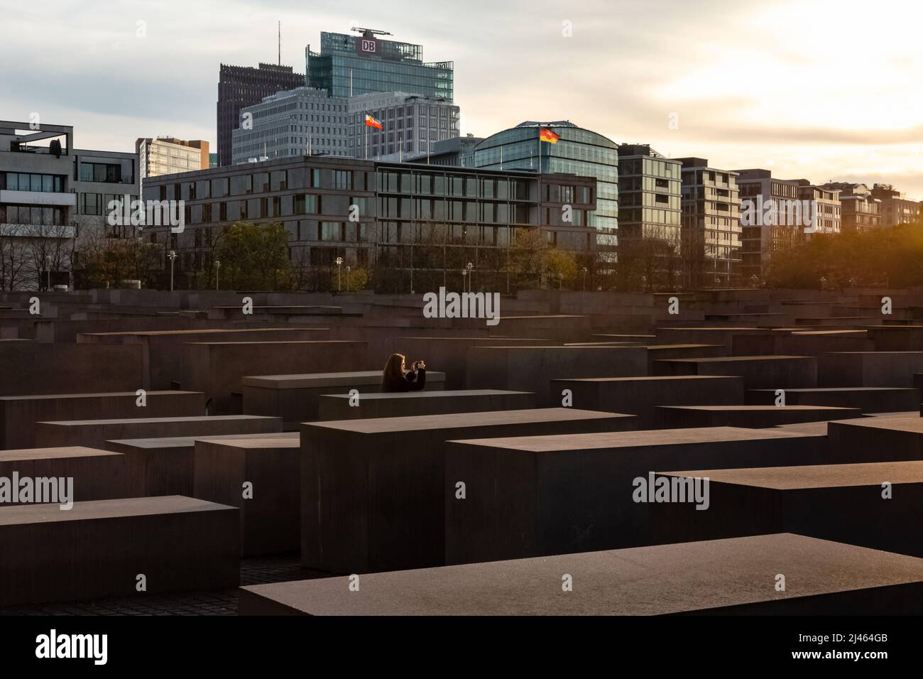 Ein Tourist, der vor Sonnenuntergang im Herbst am Denkmal für die ermordeten Juden Europas (Holocaust-Mahnmal) in Berlin fotografiert. Stockfoto