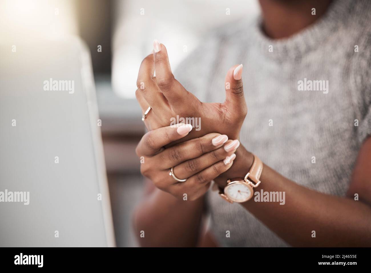 Zu viel Tipparbeit fordert ihren Tribut. Aufnahme einer Geschäftsfrau mit Schmerzen am Handgelenk, während sie in einem modernen Büro einen Laptop benutzt. Stockfoto