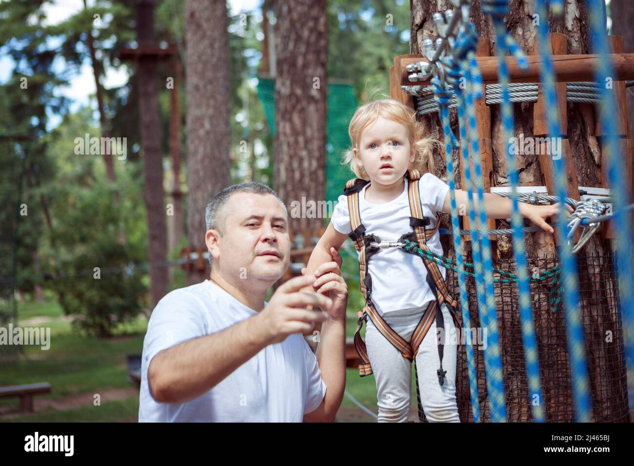 Papa hilft seiner Tochter, Hindernisse auf der Fahrt zu überwinden. Stockfoto