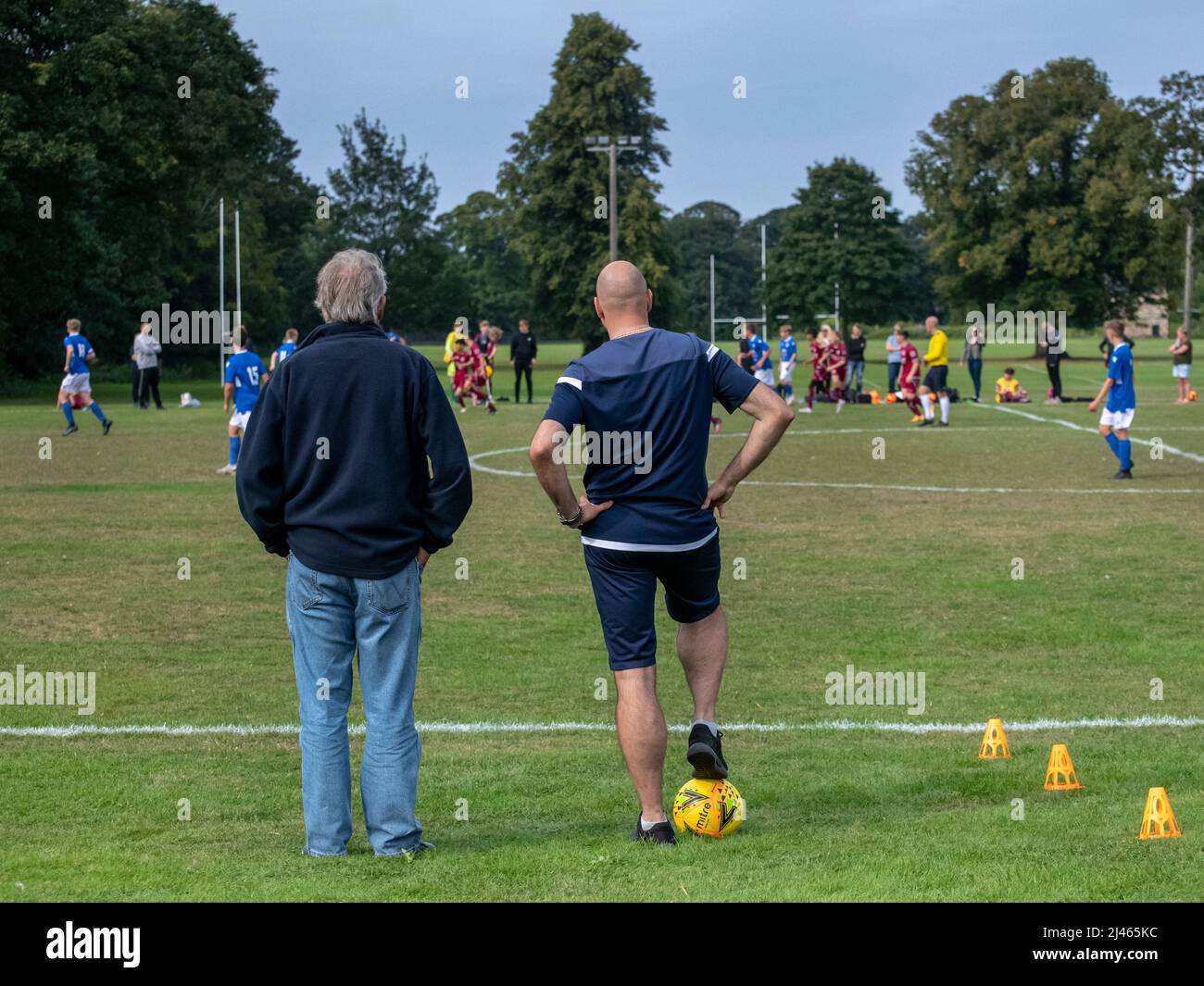 Musselburgh, Schottland, 5.. September 2021: Zwei Fußballtrainer schauen sich ein Jugendspiel an. Stockfoto