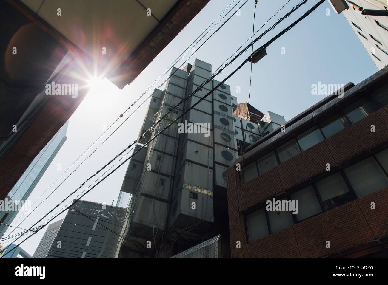 Tokio. 12. April 2022. Das am 12. April 2022 aufgenommene Foto zeigt das Nakagin Capsule Tower Building in Shimbashi, Tokio, Japan. Das Nakagin Capsule Tower Building ist ein gemischter Wohn- und Büroturm in Shimbashi in Tokio. Das Gebäude wurde 1972 erbaut und ist heute in Verfall geraten. Im März 2022 wurde bekannt gegeben, dass das Gebäude abgerissen werden soll. Quelle: Zhang Xiaoyu/Xinhua/Alamy Live News Stockfoto