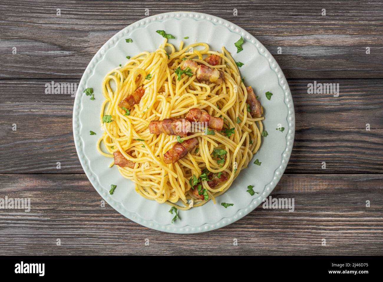 Klassische hausgemachte Pasta Carbonara mit Spaghetti, Pancetta, Ei, Parmesankäse und Sahnesauce auf Holztisch. Italienisches Essen, Blick von oben Stockfoto