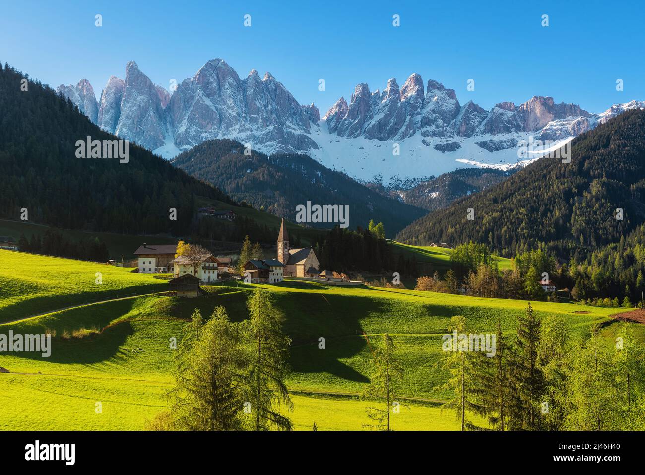 Sonnige Frühlingslandschaft der Dolomiten Alpen. Berühmtes Dorf von Santa Maddalena mit Kirche und wunderschönen Dolomiten, Val di Funes, Dolomiten, Italien Stockfoto