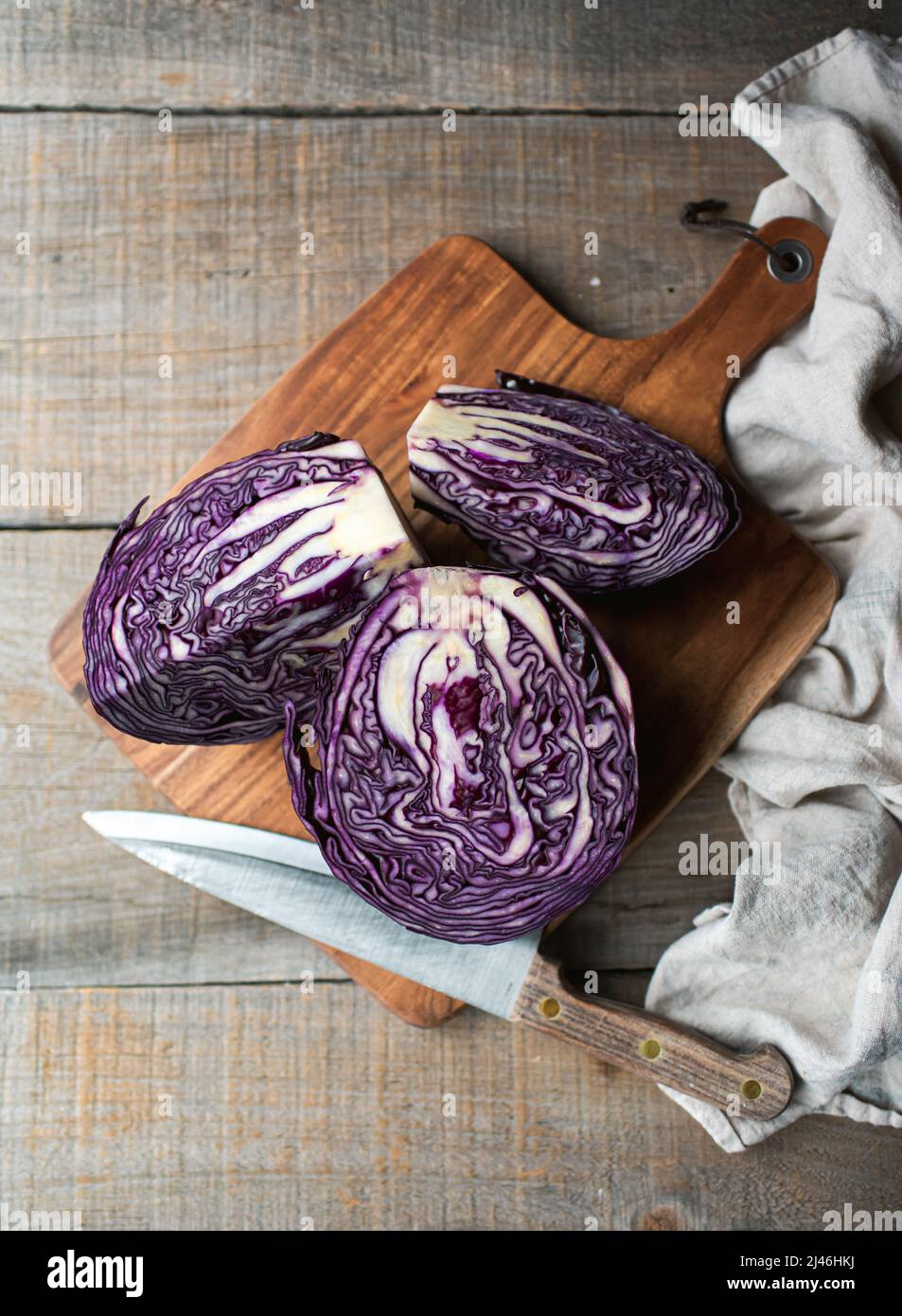 Overhead von geschnittenem Rotkohl auf einem hölzernen Schneidebrett auf dem Tisch. Stockfoto