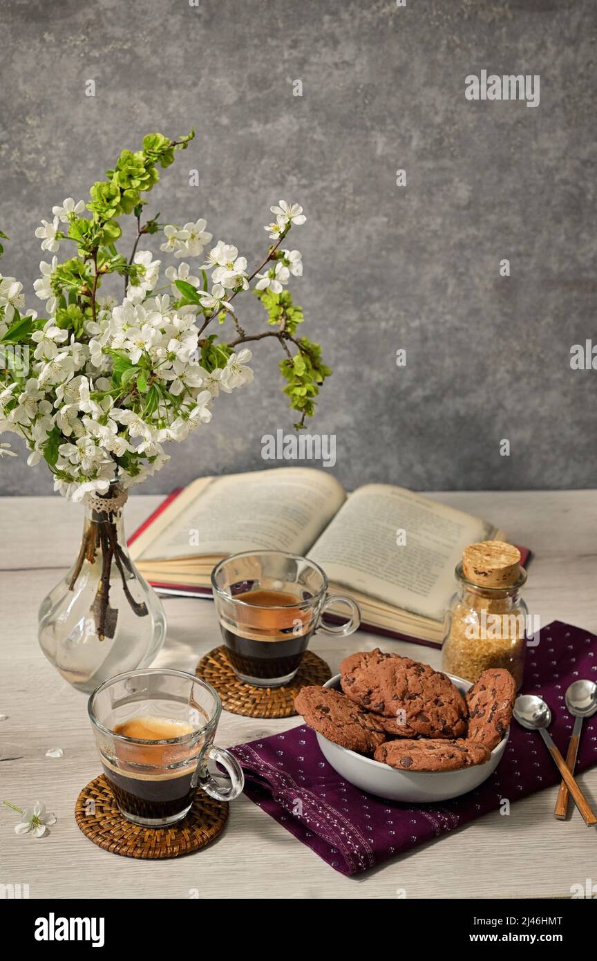 Frühlingstisch mit Espressotassen und Schokoladenkekse Stockfoto