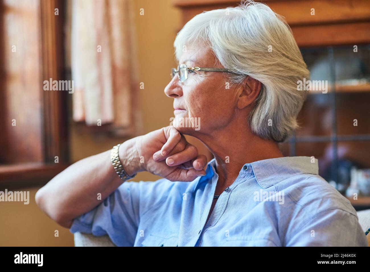 Über die vergangenen Jahre nachdenken. Eine kurze Aufnahme einer älteren Frau, die zu Hause nachdenklich aussieht. Stockfoto