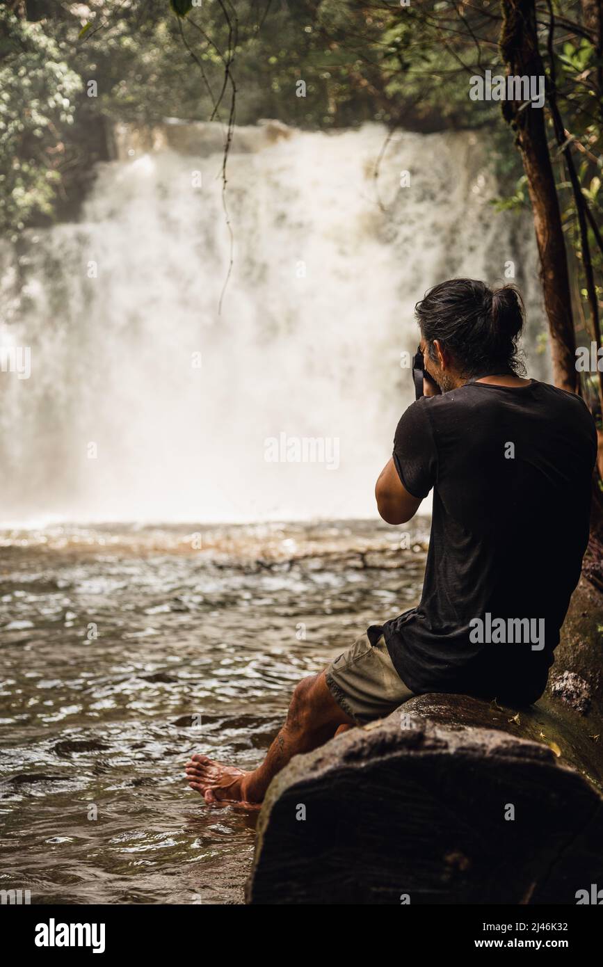 Mann, der professionell einen Wasserfall fotografiert Stockfoto