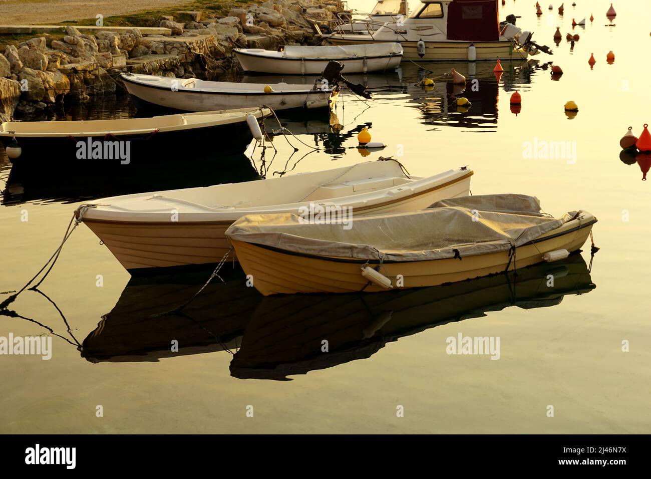 Kleiner Hafen an der ländlichen Küste mit schwimmenden Booten und Bojen zum Festmachen von Booten Stockfoto