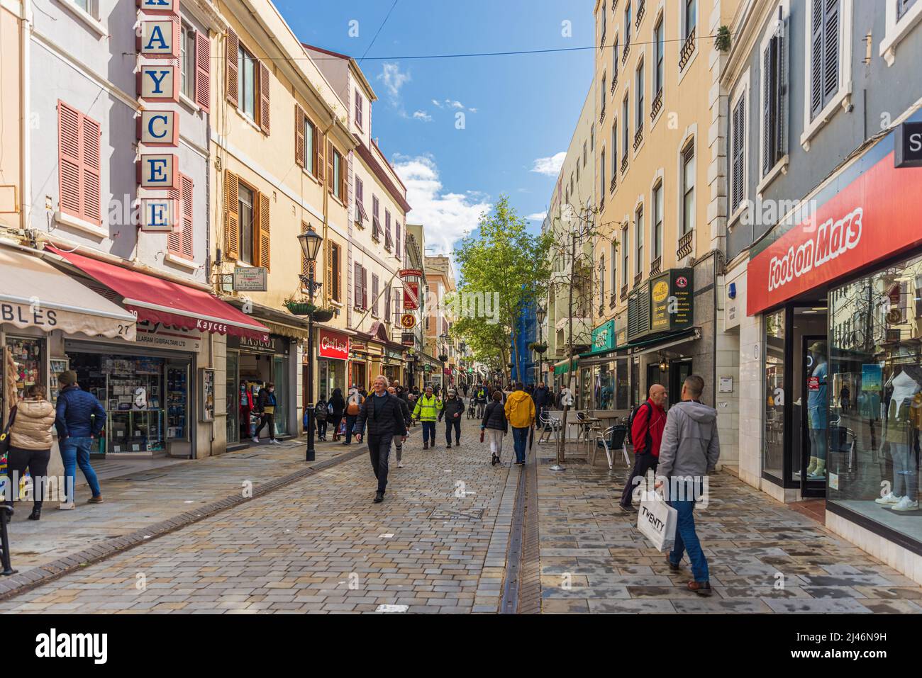 GIBRALTAR, Großbritannien - 7. APRIL 2022 - Touristen und Einkäufer, die an sonnigen Tagen auf der Main Street spazieren, Innenstadt von Gibraltar, British Overseas Territory. VEREINIGTES KÖNIGREICH. Stockfoto