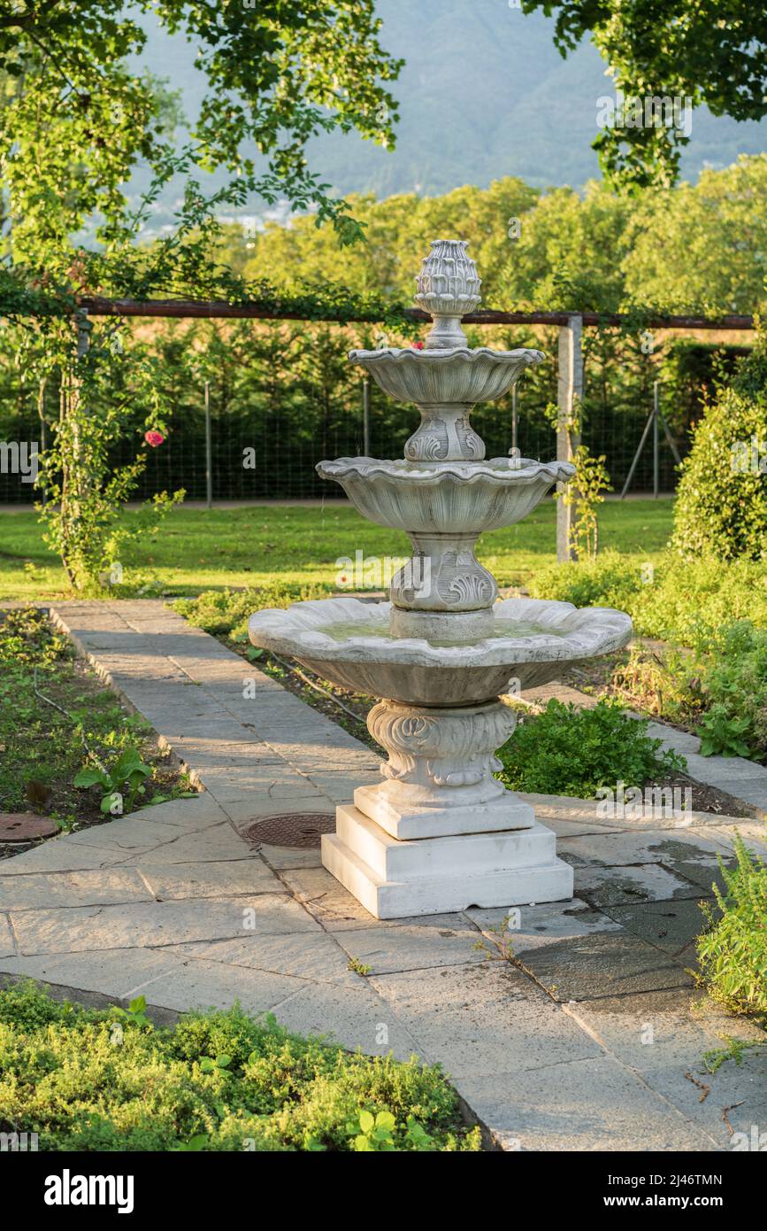 Klassische Springbrunnen Garten Dekoration mit grünen Bäumen im Hintergrund  Stockfotografie - Alamy