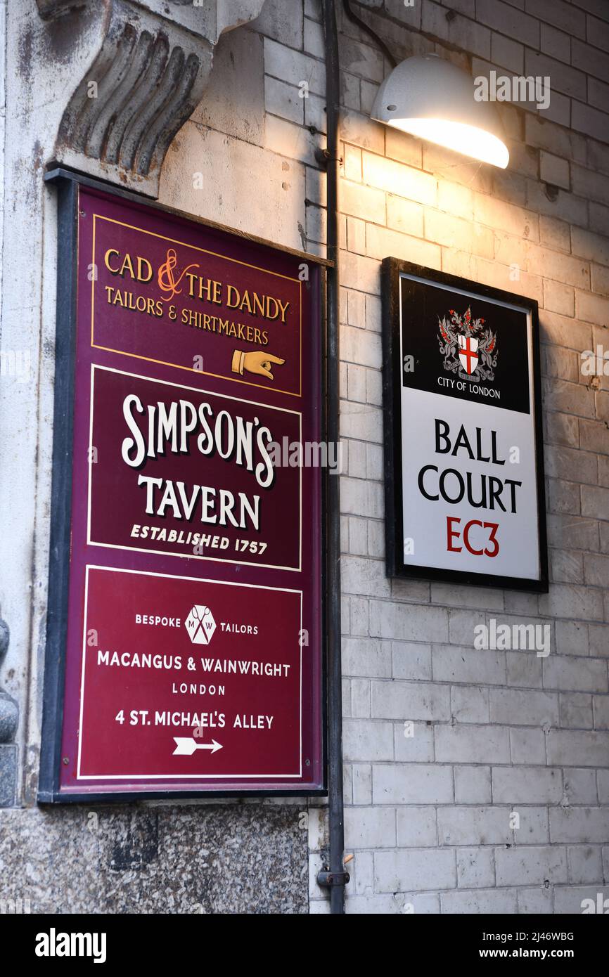 Schilder mit den Namen von Unternehmen, die sich in der engen Gasse des Ball Court in der City of London, dem Finanzzentrum von London, befinden Stockfoto