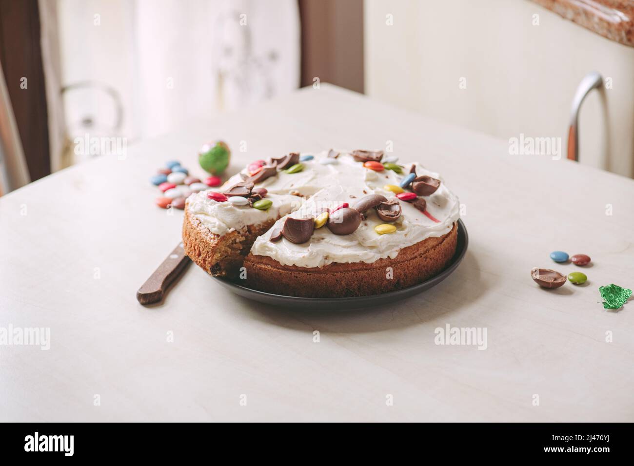 Hausgemachter Karottenkuchen mit Frischkäse und Schokoladeneiern. Ostern festliche Backen, eine Schicht Kuchen. Stockfoto