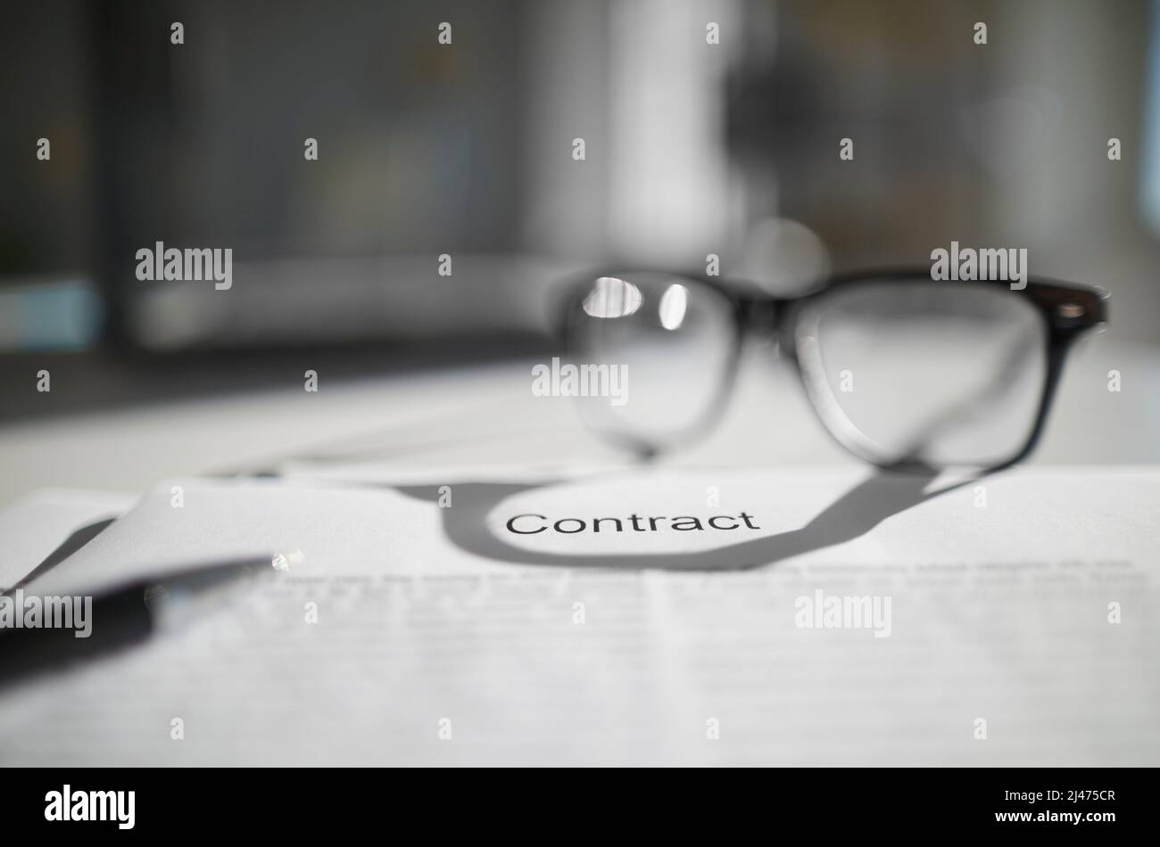 Ein Vertrag auf Arbeitstisch mit Brille und Bleistift. Die Dokumente sind zum Signieren bereit. Geschäftskonzept. Kooperationsvereinbarung. Stockfoto