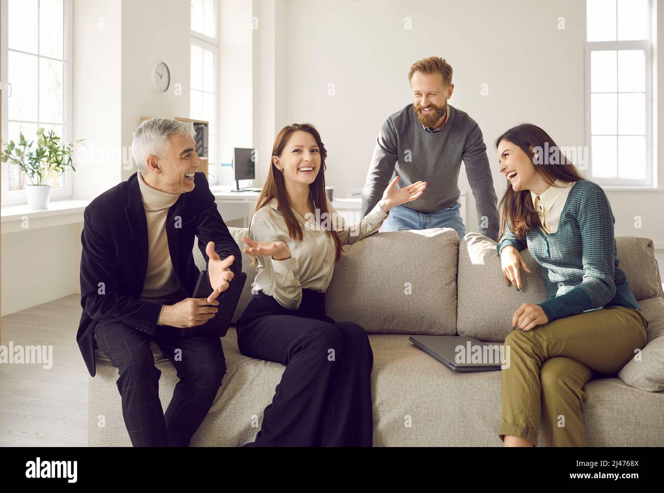 Eine Gruppe von glücklichen Kollegen, die während ihrer Arbeitspause über etwas Lustiges lachen Stockfoto