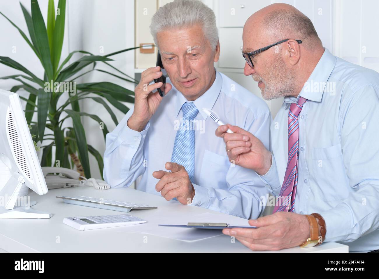 Zwei Geschäftsleute, die am Schreibtisch sitzen und arbeiten Stockfoto