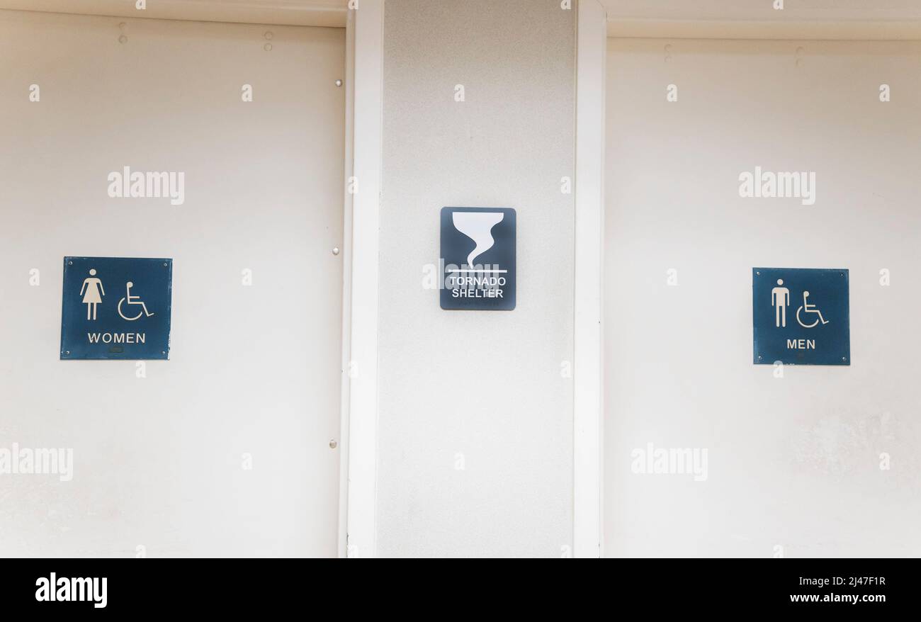 Ein Tornado Shelter Schild zwischen den Badtüren von Männern und Frauen in einem Einzelhandelsgeschäft in North Central Florida. Stockfoto