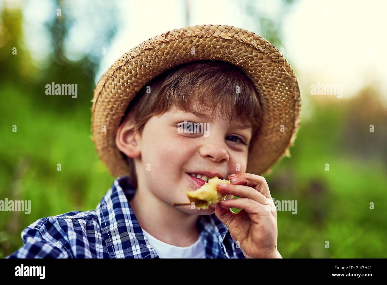 Ich halte gerade für einen Snack auf meiner Erkundungstour im Freien. Porträt eines kleinen Jungen, der sich im Freien amüsant. Stockfoto