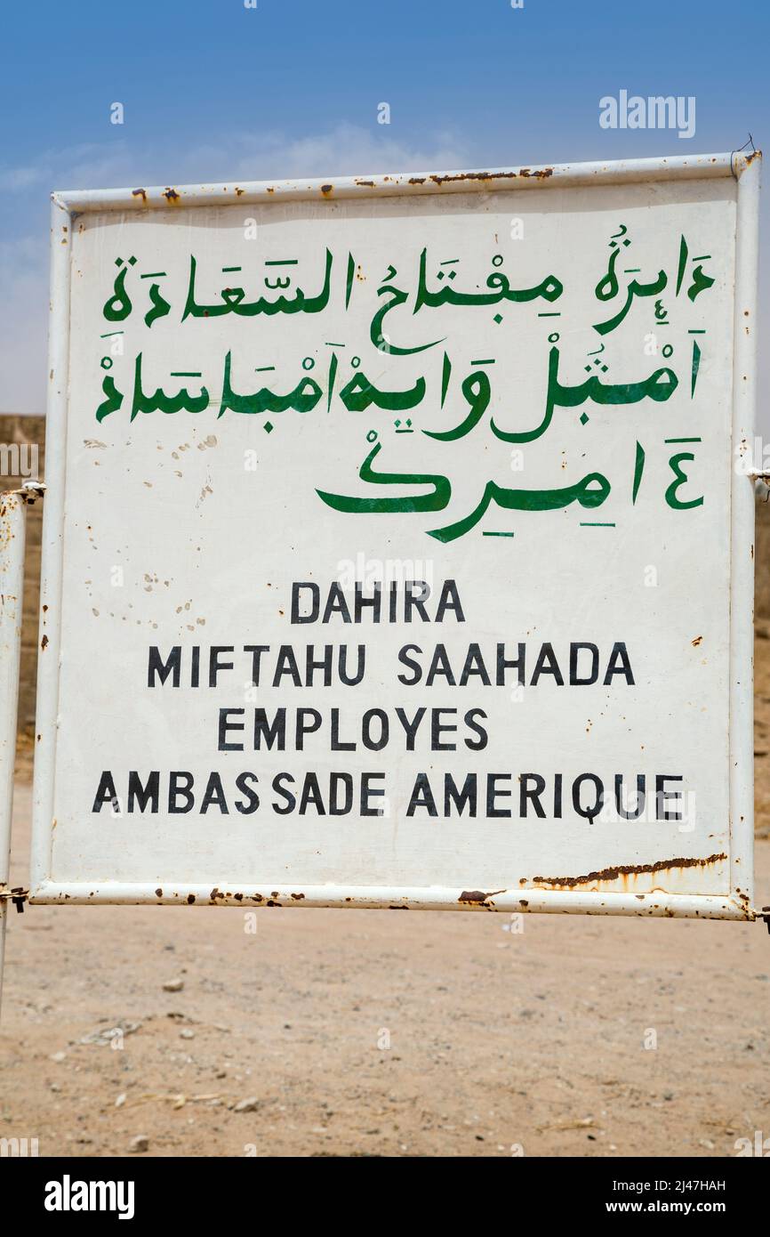 Senegal, Touba. Wolof, geschrieben in arabischer und lateinischer Schrift. Das Schild weist darauf hin, dass ein Haus im Besitz der Mitarbeiter der amerikanischen Botschaft ist. Stockfoto