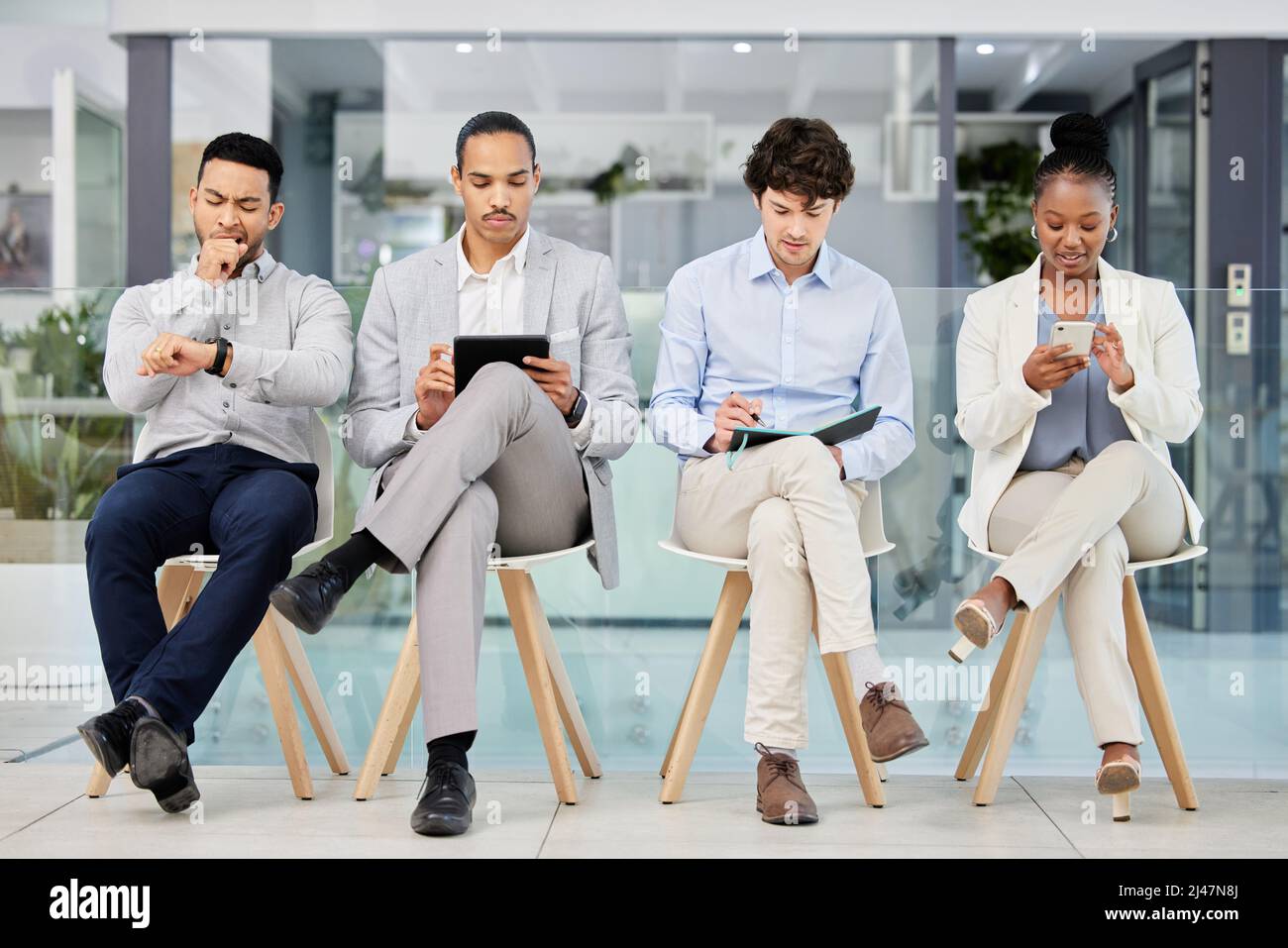 Erste Schritte für eine weitere großartige Kampagne. Aufnahme einer Gruppe von Menschen, die darauf warten, für einen Job in einem modernen Büro interviewt zu werden. Stockfoto