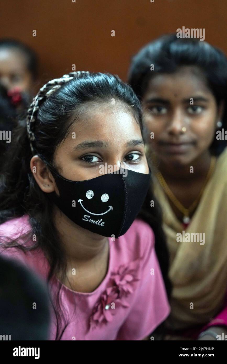 Das indische Mädchen trägt eine Corona Gesichtsmaske mit der Aufschrift Smile. Kalkutta, Indien Stockfoto