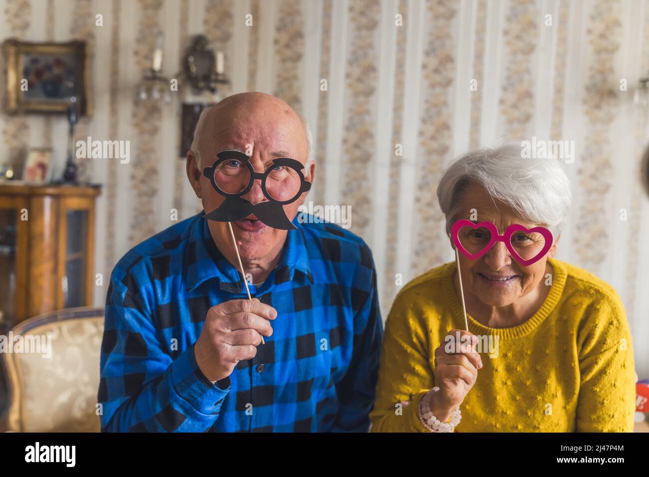 Fröhliche Großeltern mit niedlichen Gläsern Senioren unterstützen Konzept Wohnzimmer Medium closeup . Hochwertige Fotos Stockfoto