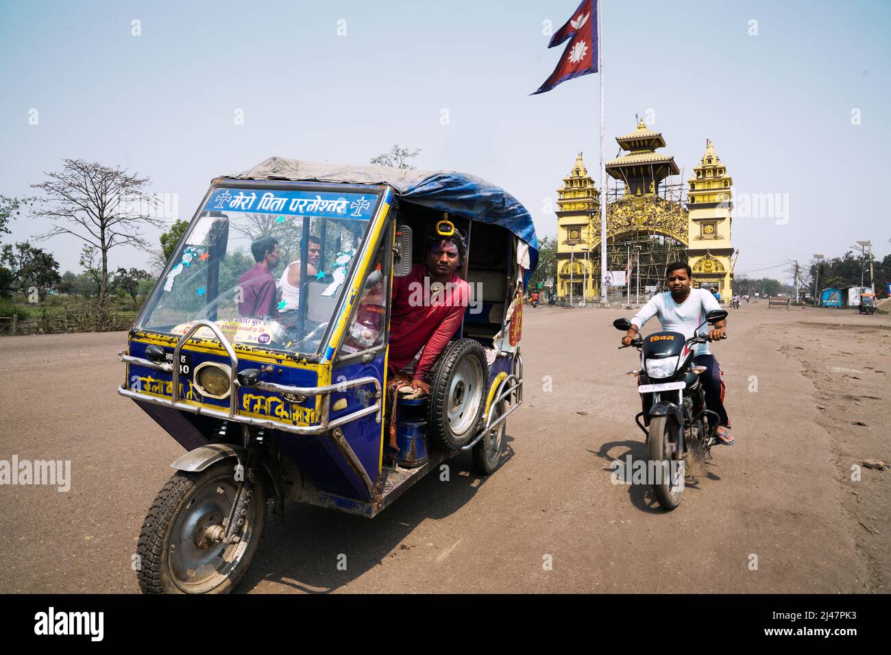 Motorräder an der Grenze vor Nepals Flagge am Shankaracharya Gate, dem Tor nach Indien in der nepalesischen Grenzstadt Birgunj Stockfoto