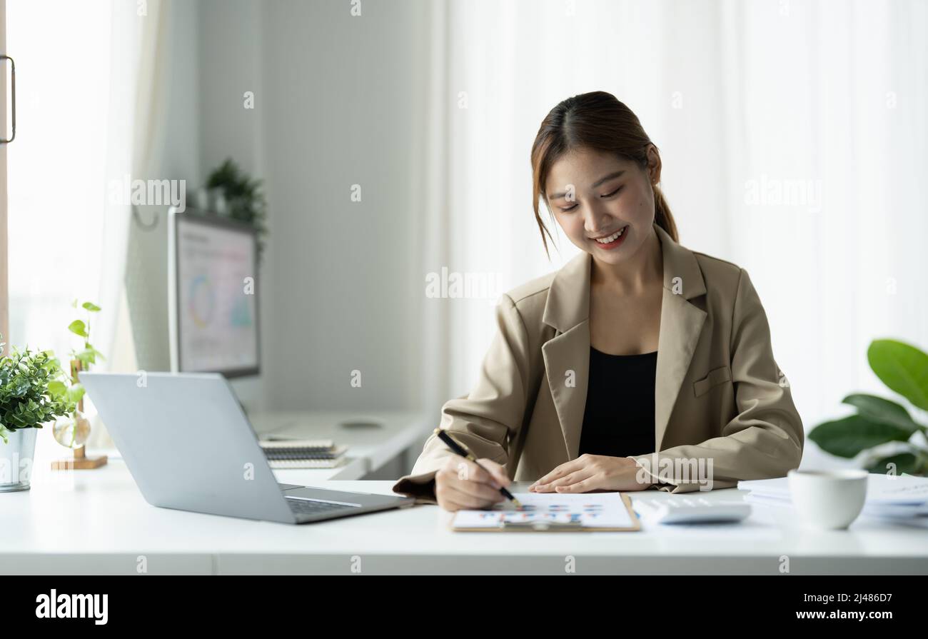 Business Asian Frau mit Laptop für die mathematische Finanzierung auf Holztisch im Büro, Steuern, Buchhaltung, Finanzkonzept Stockfoto