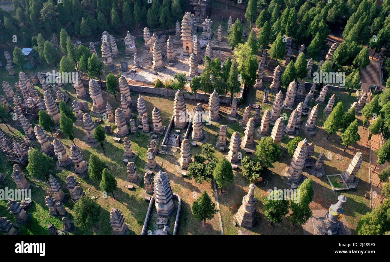 Zhengzhou. 7. April 2022. Luftaufnahme vom 7. April 2022 zeigt den Pagodenwald am Shaolin Tempel in Dengfeng, der zentralchinesischen Provinz Henan. Zu den historischen Denkmälern von Dengfeng im „Zentrum von Himmel und Erde“ gehört der antike architektonische Komplex am Songshan-Berg in Henan, Zentralchina.einige dieser Gebäude, die im Laufe von neun Dynastien erbaut wurden, sind die besten Beispiele der alten chinesischen Architektur, die sich den Ritualen, Wissenschaft, Technologie und Bildung widmet.Quelle: Li An/Xinhua/Alamy Live News Stockfoto