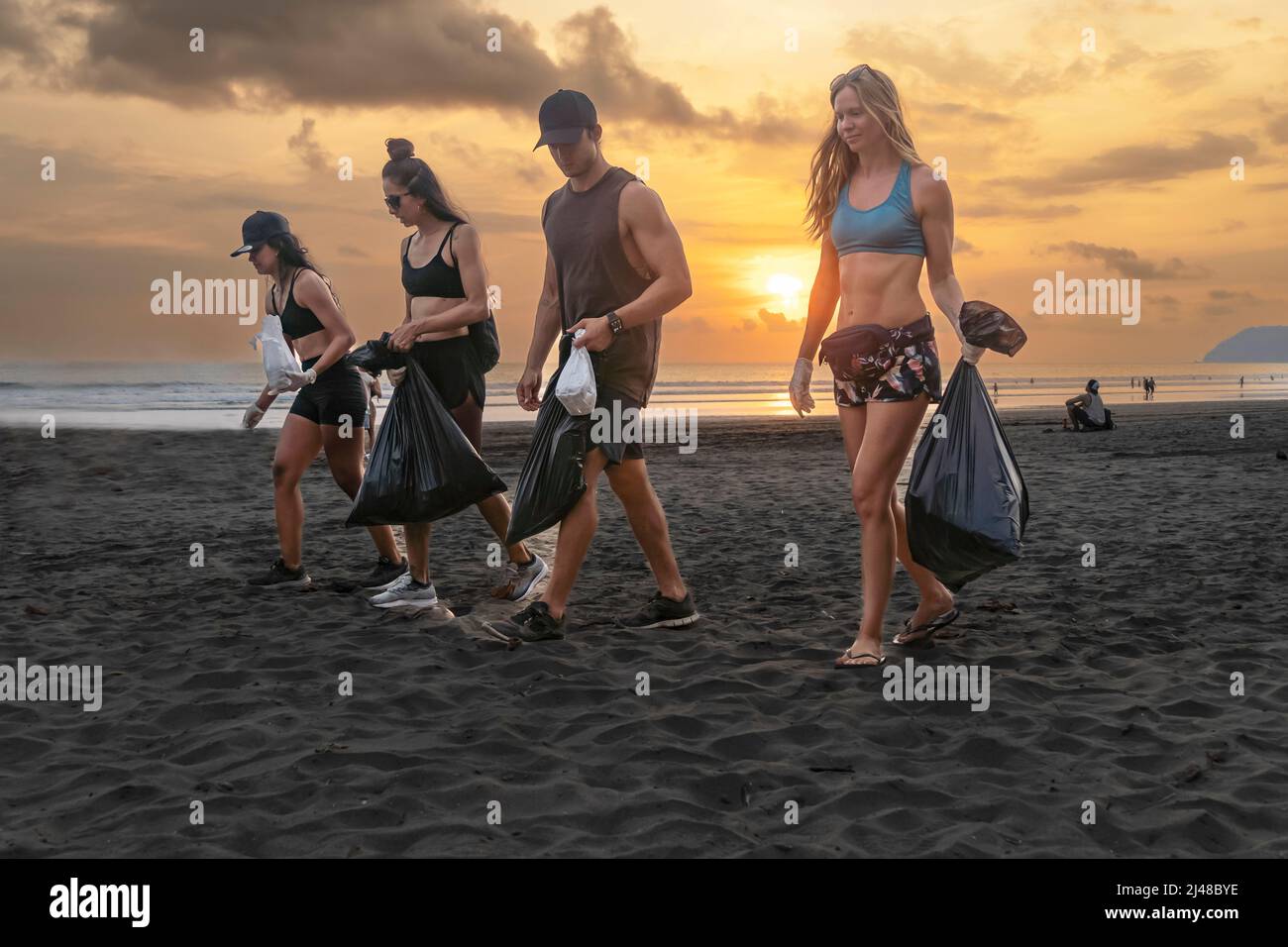 Ein Team von Mitarbeitern, die sich für das Recycling stark machen und Plastikmüll in Tüten sammeln Stockfoto