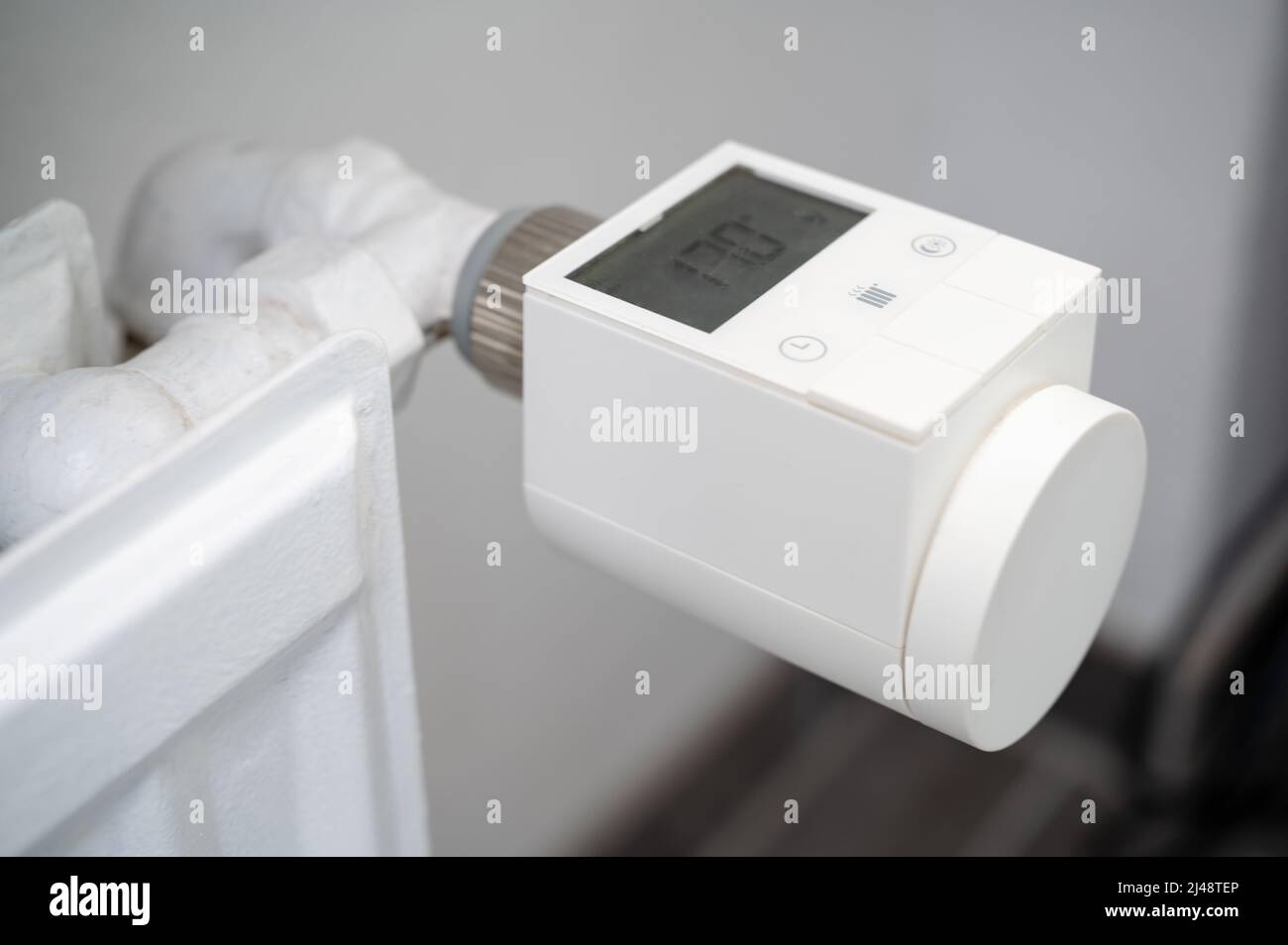 Modernes intelligentes Heizventil mit Thermostat, das an einen alten Heizkörper für Warmwasserbereitung nachgerüstet wurde, um die Raumtemperatur zu regeln Stockfoto Modernes intelligentes Heizventil mit Thermostat, das an einen alten Heizkörper für Warmwasserbereitung nachgerüstet wurde, um die Raumtemperatur zu regeln Stockfoto