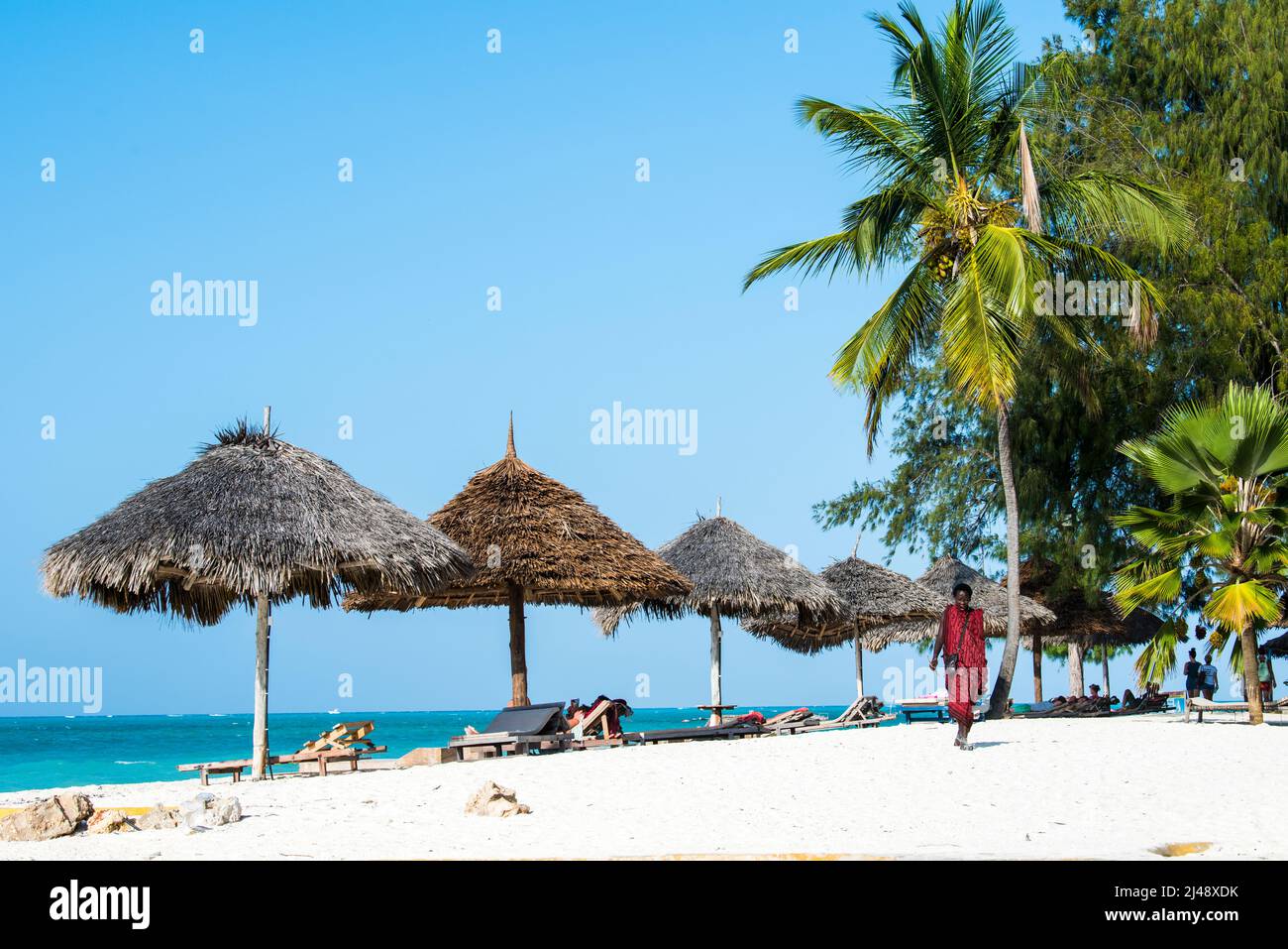 Sansibar, Tansania - April 22,2022: Masai-Krieger in traditioneller Kleidung am Sandstrand der Insel Sansibar. Stockfoto