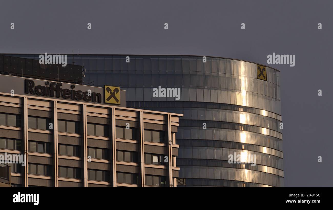 Blick auf die Spitze des Hauptsitzes der Raiffeisen Bankengruppe in Wien, Österreich, in einem modernen Bürogebäude mit Logo und Sonnenlicht. Stockfoto