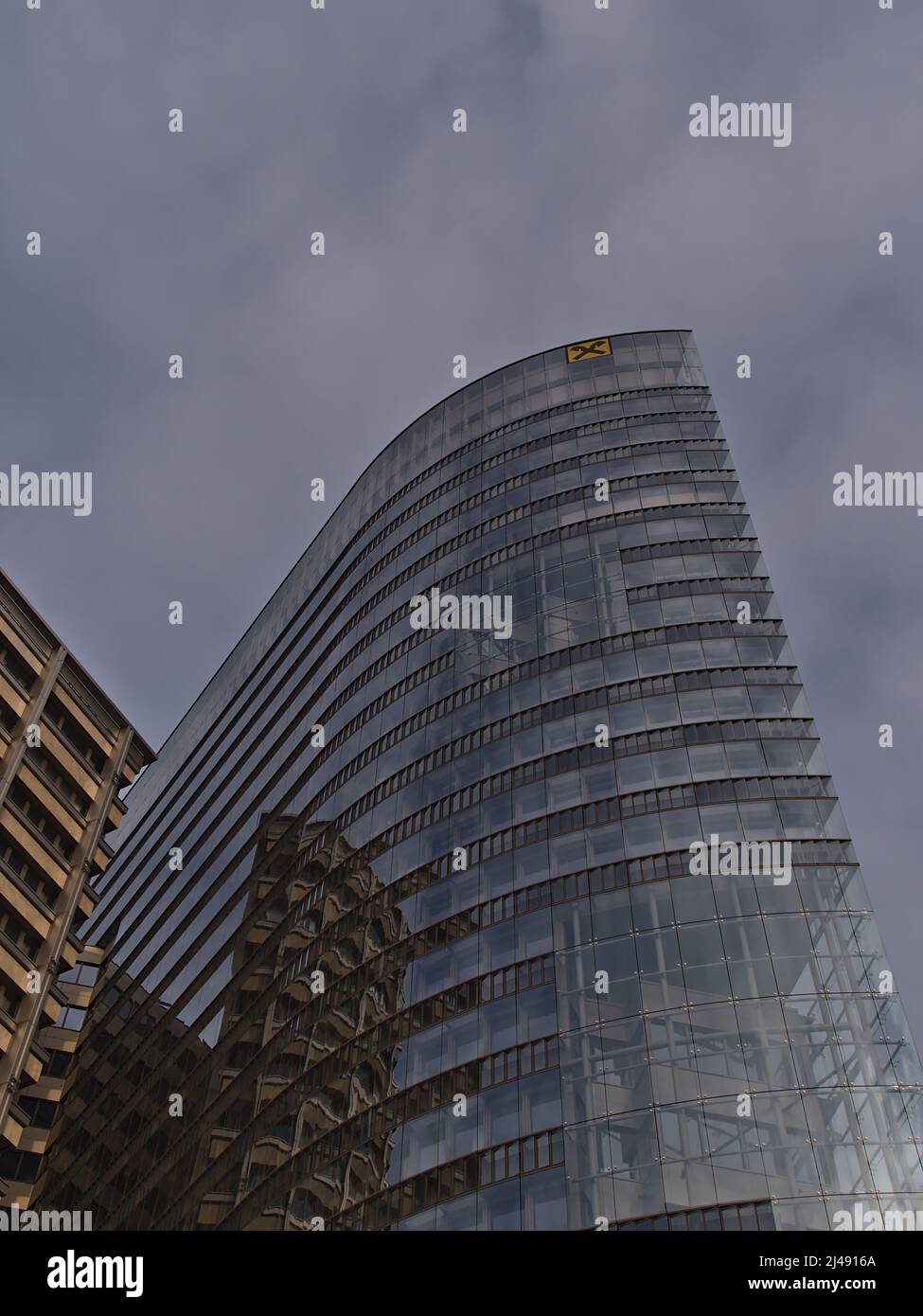 Niederwinkelansicht der Raiffeisen Bankengruppe in Wien, Österreich, in einem modernen Bürogebäude mit Logo-Reflexionen. Stockfoto
