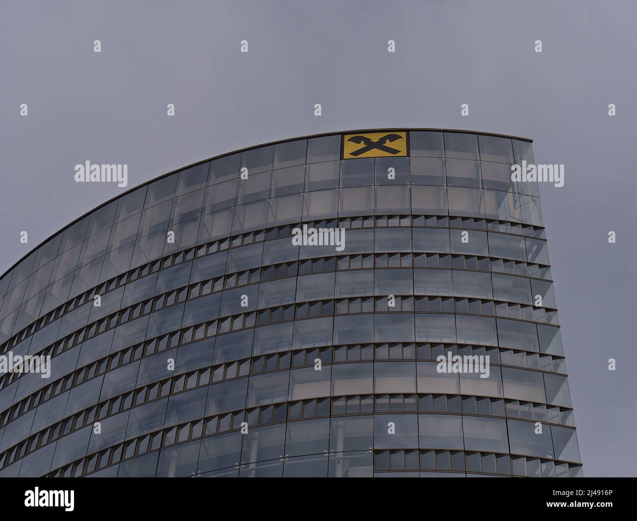 In einem modernen Bürogebäude mit gelbem Logo ist die Spitze des Hauptquartiers der Raiffeisen Bankengruppe in Wien, Österreich, in einer tiefen Ansicht. Stockfoto